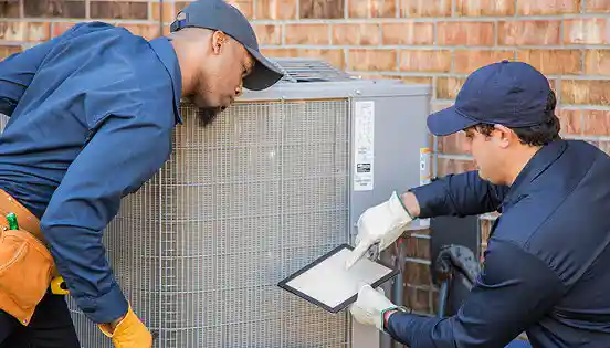 Two skilled technicians collaborating on a new AC unit installation.